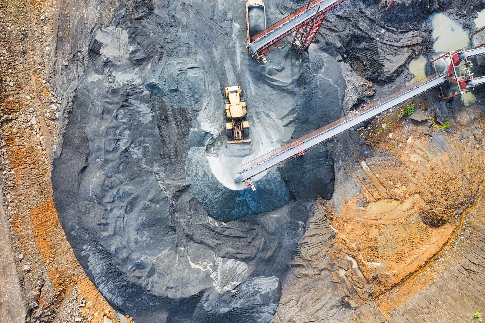 Aerial view of excavation equipment and conveyors at a resource development site